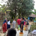 Haru di Lokasi TMMD, Puluhan Ibu dan Anak-anak Turun Tangan Siram Jalan Cor Bersama Satgas TNI